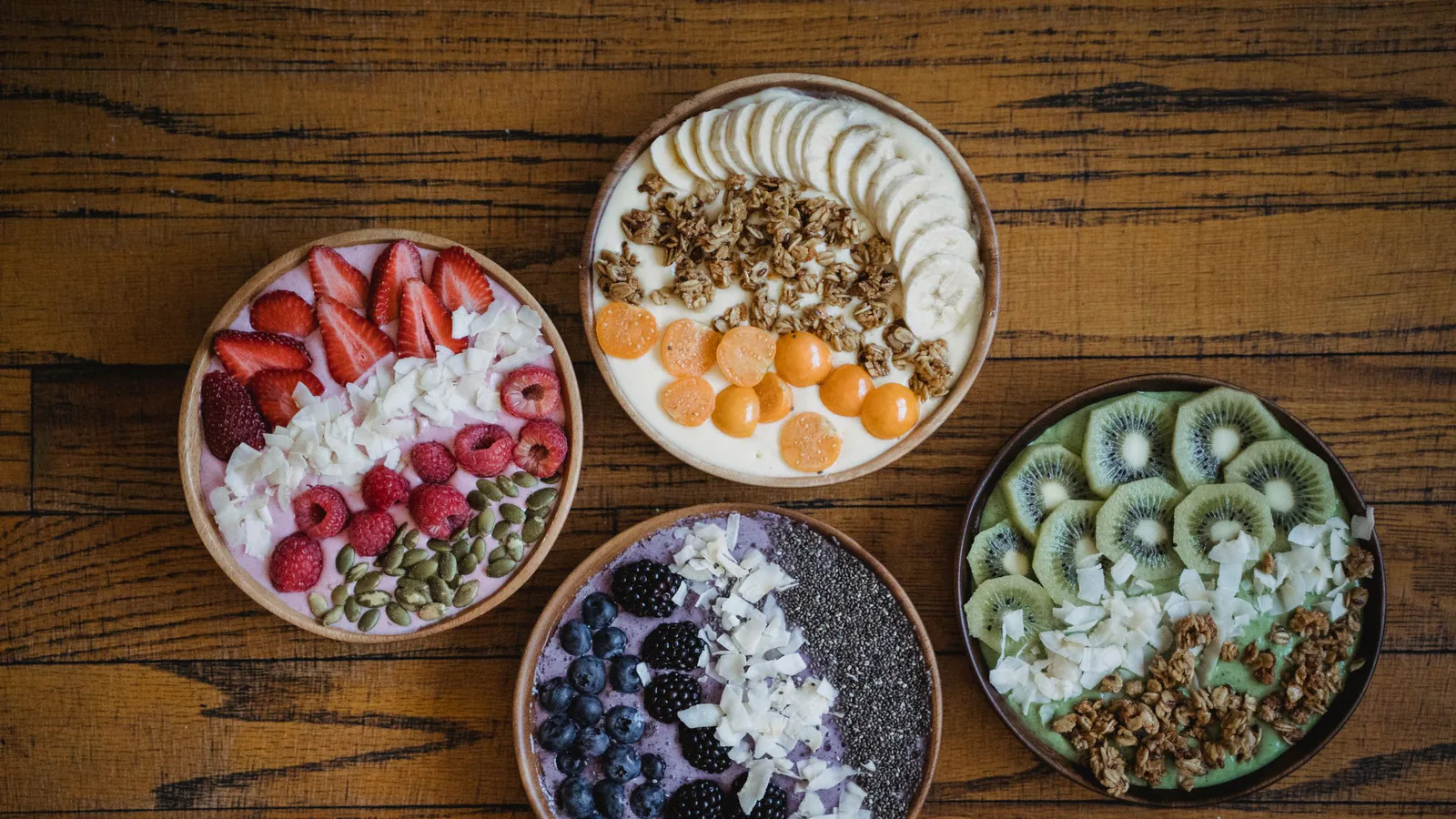 Açaí Paradise, nacida en Granada, abre su modelo de franquicia para crecer por toda España | ZonaFranquicia Cuatro boles de açaí coloridos con frutas, frutos secos y granola sobre mesa de madera | ZonaFranquicia