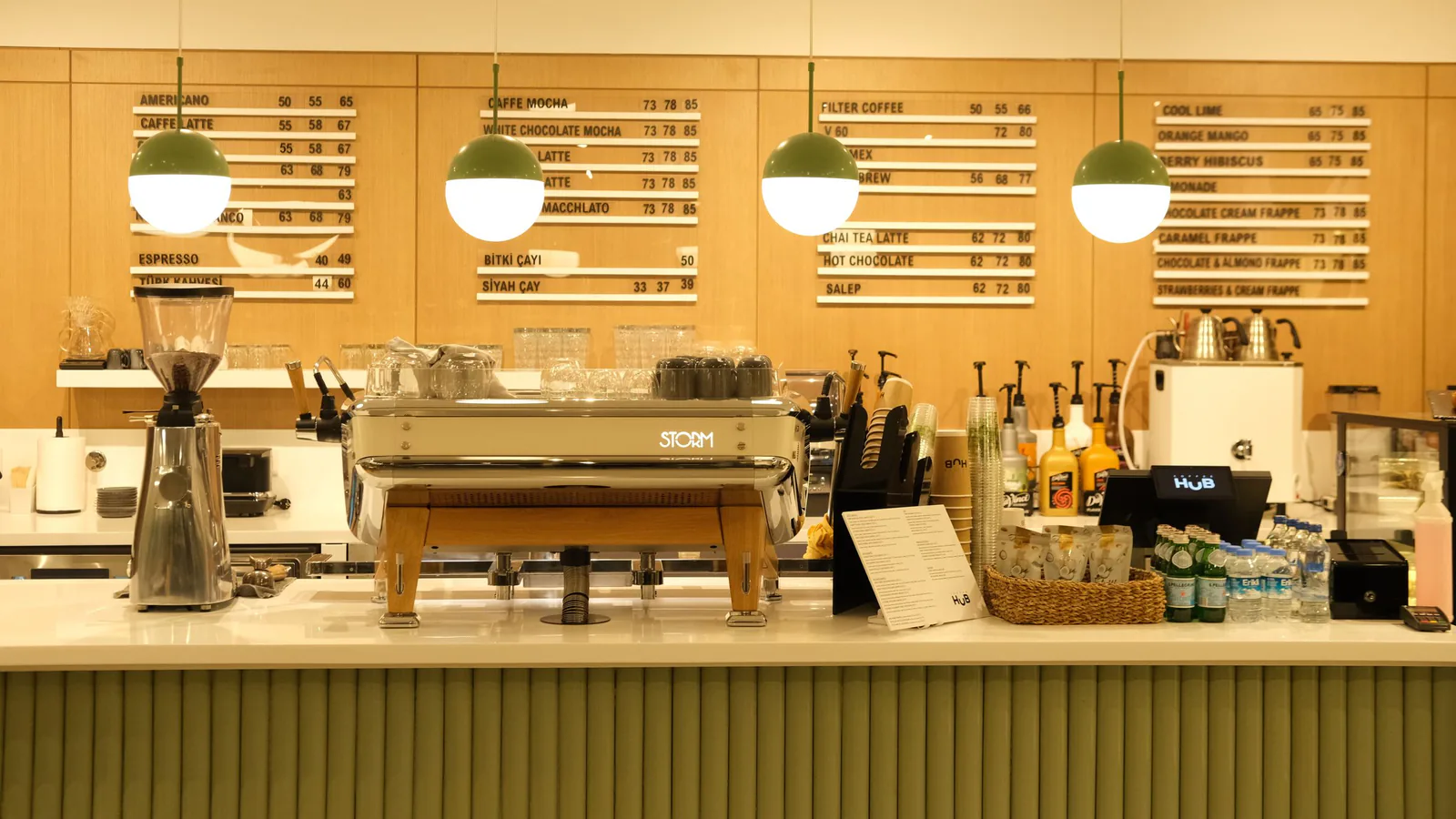 Café de especialidad, silver economy y energía: los sectores de franquicia que más crecen en España… | ZonaFranquicia Mostrador de una cafetería moderna con máquina de espresso y tableros de menú iluminados. | ZonaFranquicia