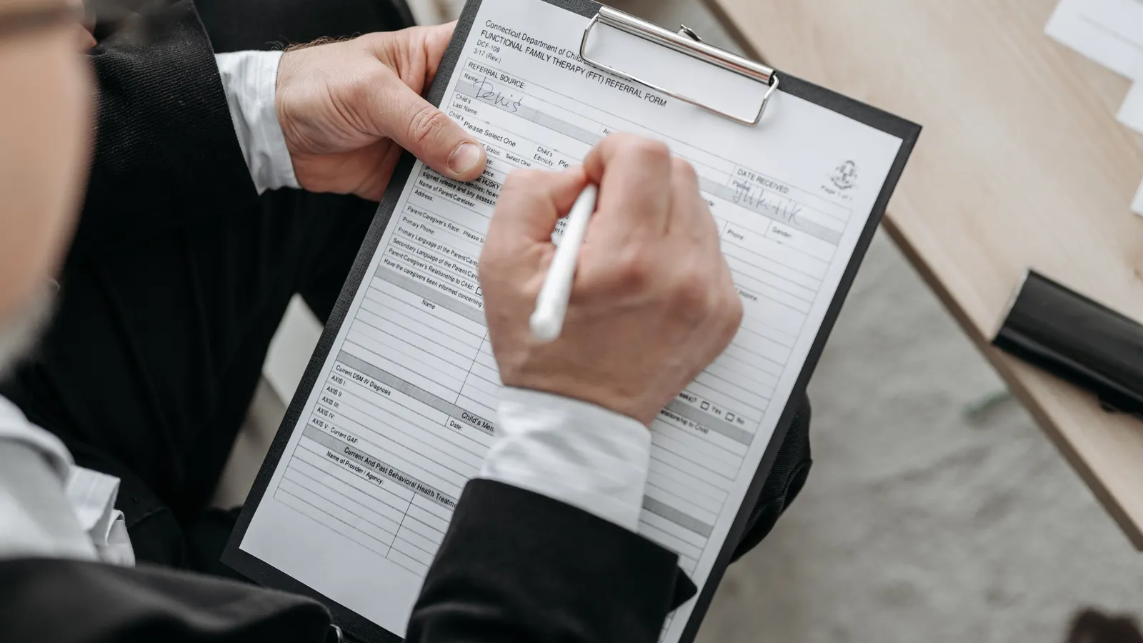 Emprendedor firmando contrato de franquicia con documentos y dinero sobre mesa de oficina | ZonaFranquicia