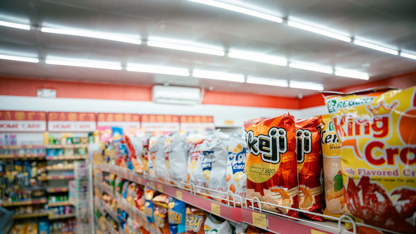 Consum invertirá 100 millones en Barcelona para abrir 20 supermercados en Cataluña, 13 de ellos fra… | ZonaFranquicia Pasillo de supermercado con estanterías llenas de productos variados y clientes comprando | ZonaFranquicia