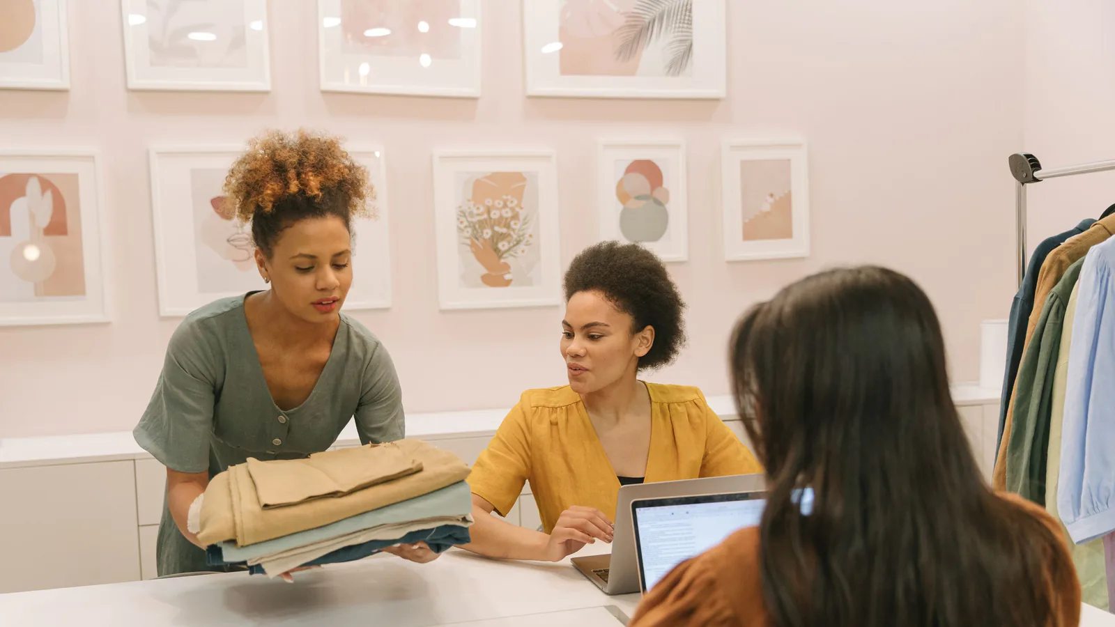 De 1 a 10 locales en 5 años: la estrategia de escalado en franquicias | ZonaFranquicia Tres mujeres trabajando juntas en una boutique moderna, discutiendo estrategias de negocio y crecimiento | ZonaFranquicia