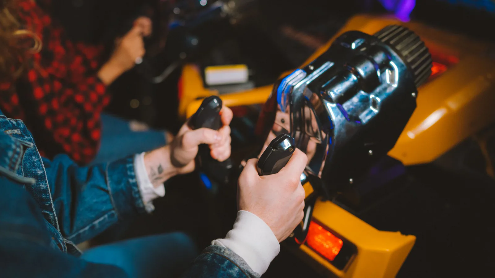 Varias personas disfrutando de simuladores de carreras en un entorno de arcade vibrante y moderno | ZonaFranquicia