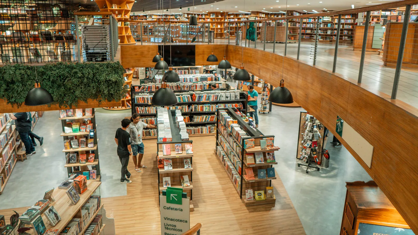 Fnac apuesta por la franquicia en España: quiere llegar a 50 tiendas antes de 2030 | ZonaFranquicia Interior de una librería moderna con estanterías de madera y clientes mirando libros | ZonaFranquicia