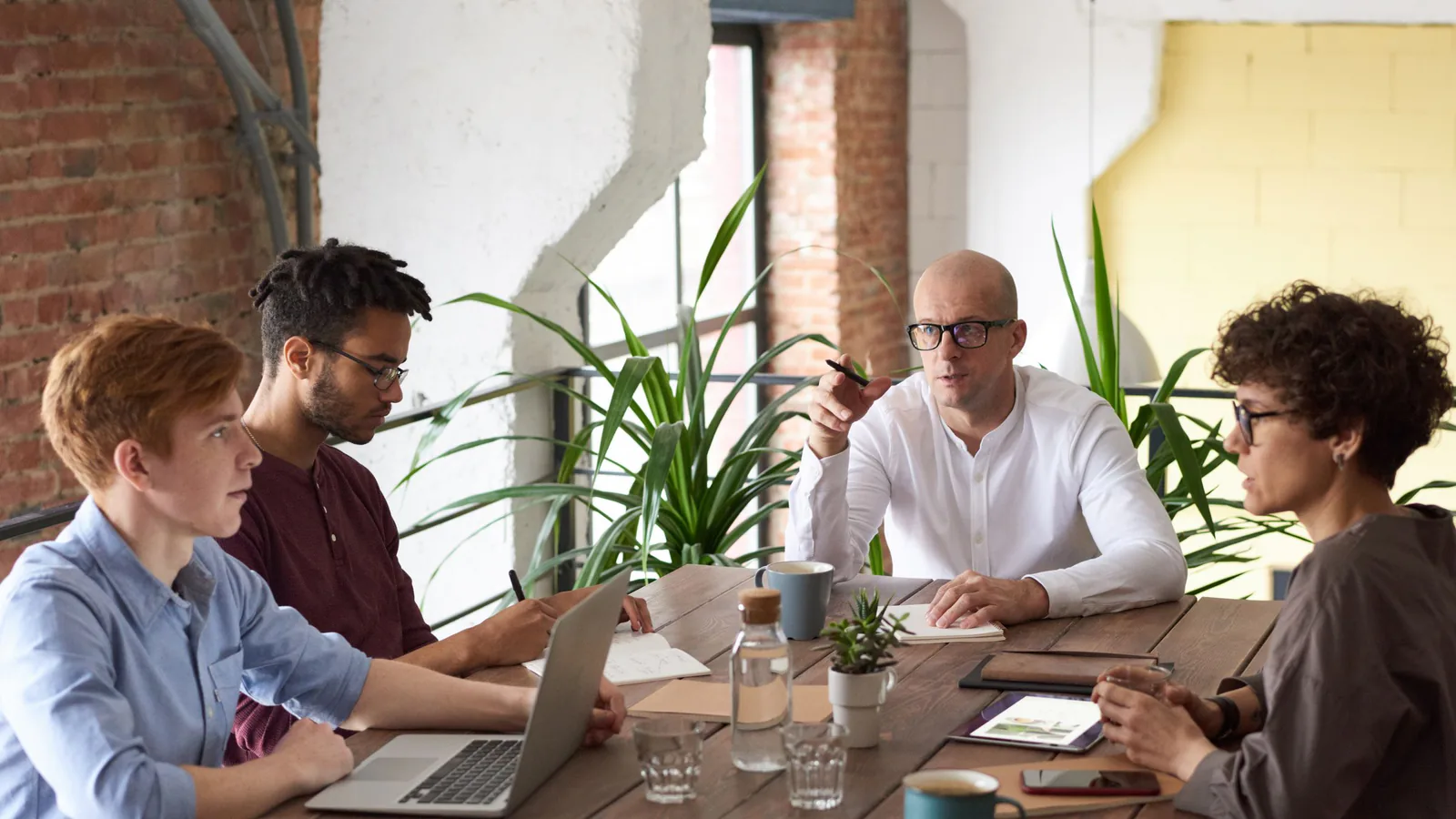 Franchise Forum llega hoy a Barcelona con más de 40 marcas y 400 reuniones ya agendadas con futuros… | ZonaFranquicia Profesionales colaborando alrededor de una mesa de trabajo con laptops y documentos en reunión de negocios | ZonaFranquicia