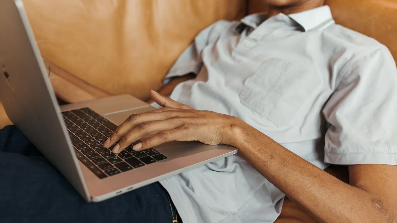 Franquicia y conciliación: trabaja menos, gana más | ZonaFranquicia Hombre con auriculares trabajando en laptop desde el sofá, representando el trabajo remoto moderno y relajado | ZonaFranquicia