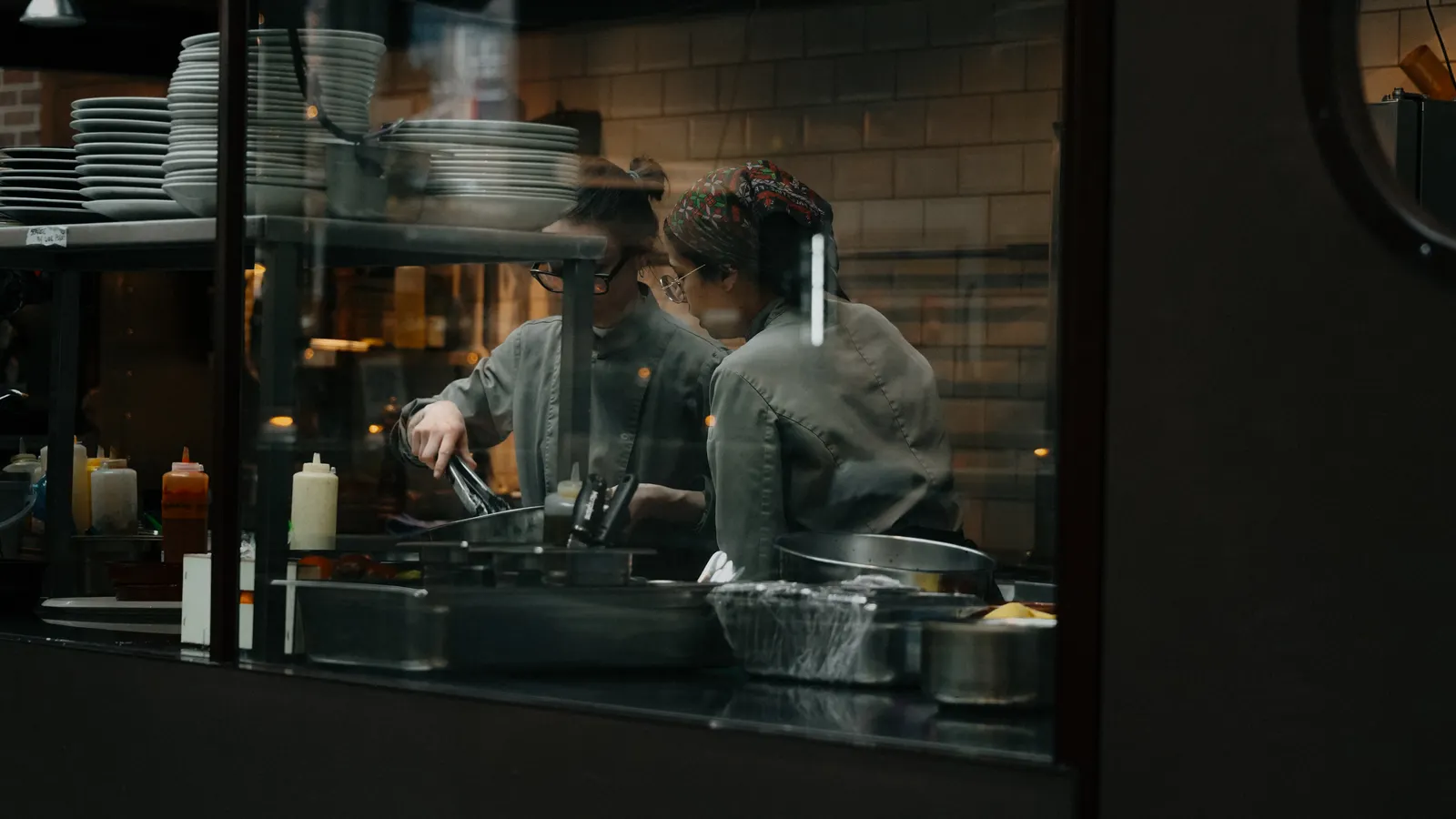 Franquicias de hostelería: claves para triunfar en el sector | ZonaFranquicia Equipo de trabajo en cocina de restaurante franquiciado sirviendo platos a clientes satisfechos | ZonaFranquicia