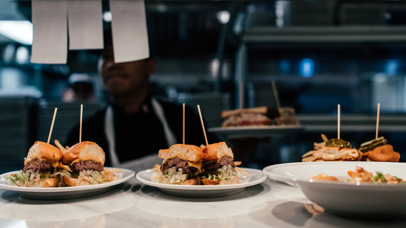 La Pepita Burger Bar, la hamburguesería gourmet gallega, prepara su salto a Madrid, Baleares, Valen… | ZonaFranquicia Hamburguesas gourmet recién preparadas en platos, listas para servir en una cocina de restaurante | ZonaFranquicia