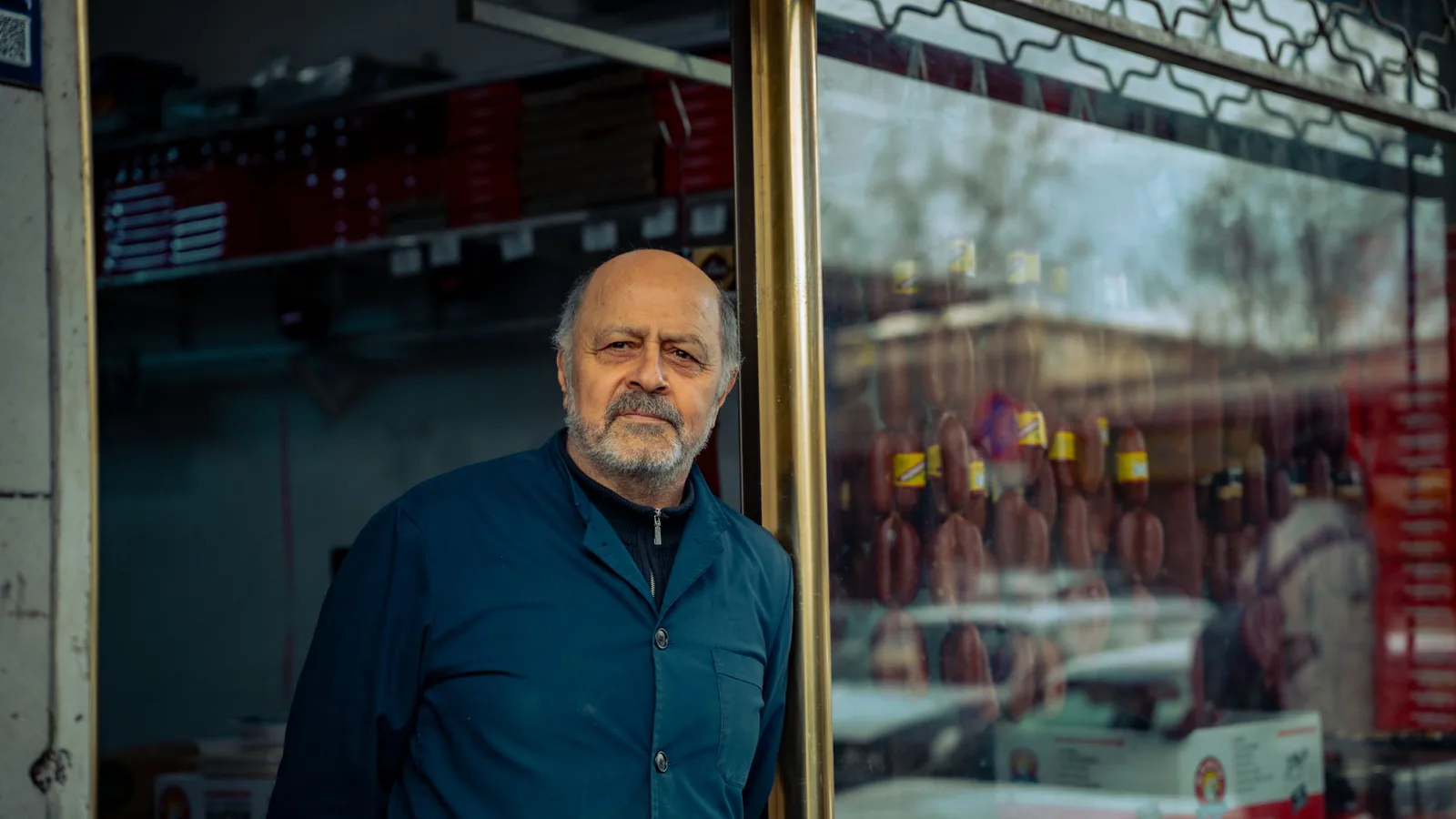 La reinversión del franquiciado: por qué el mejor termómetro de una franquicia es cuántos abren su… | ZonaFranquicia Propietario de un negocio sonriente en la entrada luminosa de su tienda | ZonaFranquicia