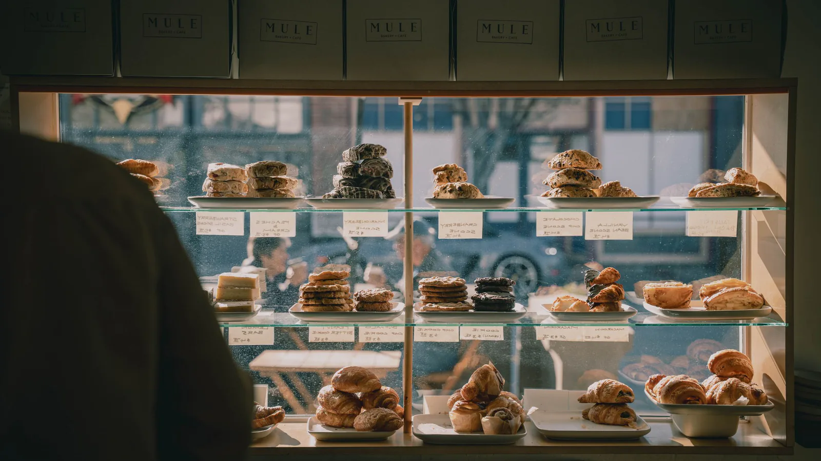 Melt Cakes llega a 12 puntos de venta y destapa su modelo de franquicia: 80.000 euros de inversión | ZonaFranquicia Vitrina de pastelería con variedad de postres y tartas artesanas en expositor de cristal, ambiente acogedor | ZonaFranquicia