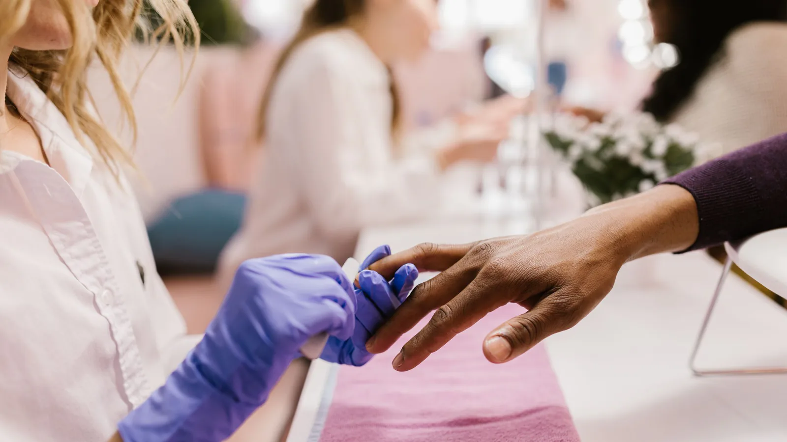 Nails & Friends busca franquiciados: la firma de manicura nacida del salón Luisa Lago quiere crecer… | ZonaFranquicia Primer plano de manicurista aplicando esmalte en un salón de uñas moderno y estilizado | ZonaFranquicia