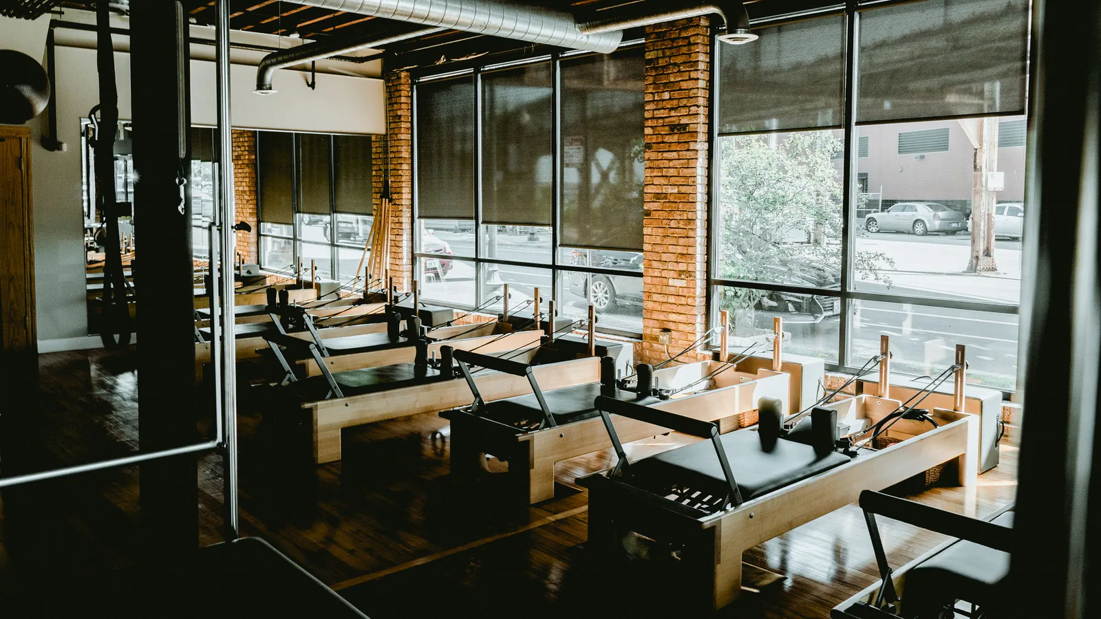 Estudio moderno de pilates con máquinas reformer y luz natural, ambiente profesional y acogedor | ZonaFranquicia