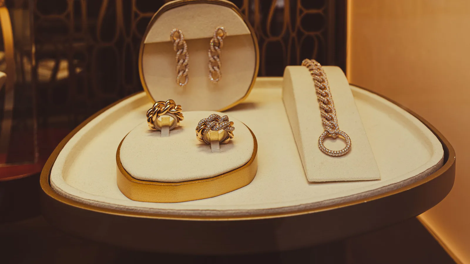Elegante exposición de joyas de oro en vitrina de tienda, mostrando anillos, pendientes y pulseras | ZonaFranquicia
