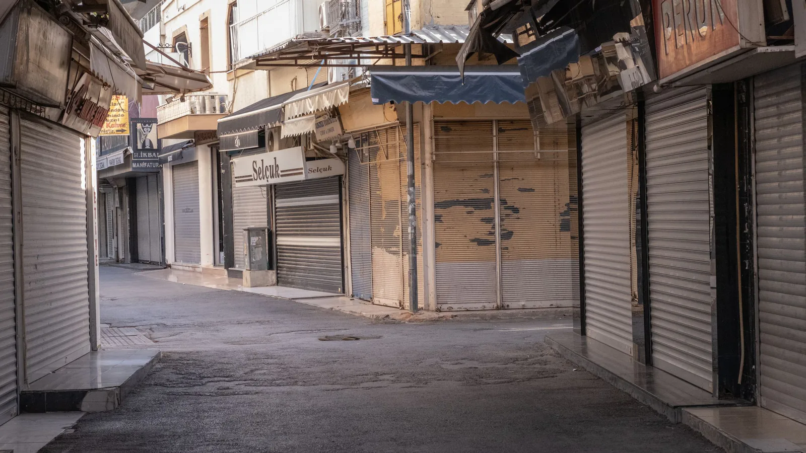 Calle desierta con tiendas cerradas y persianas bajadas en centro urbano, ilustrando declive comercial | ZonaFranquicia